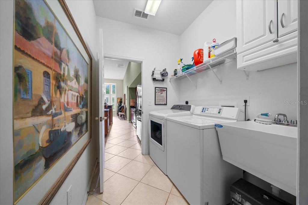 10614 Southwest 71st Terrace Road Ocala, FL 34476 - Photo 14 of 21 a utility room with cabinets washer and dryer