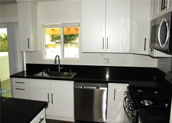 a kitchen with a sink a stove and a microwave