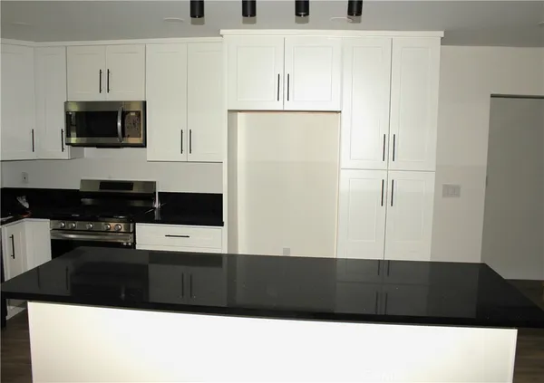 a view of kitchen with microwave and cabinets