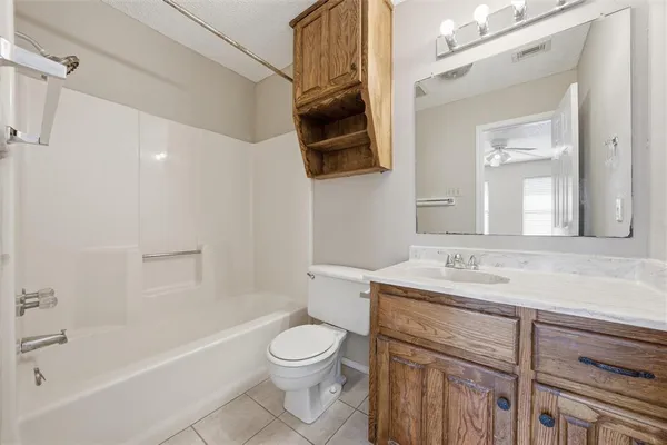 an empty room with chandelier fan and windows