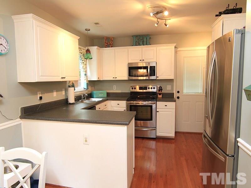 3601 Hopper Street Raleigh, NC 27616 - Photo 4 of 13 a kitchen with kitchen island granite countertop a sink appliances cabinets and a counter top space