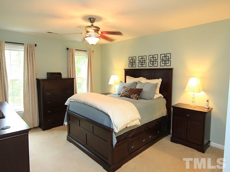 3601 Hopper Street Raleigh, NC 27616 - Photo 7 of 13 a spacious bedroom with a bed and a chandelier