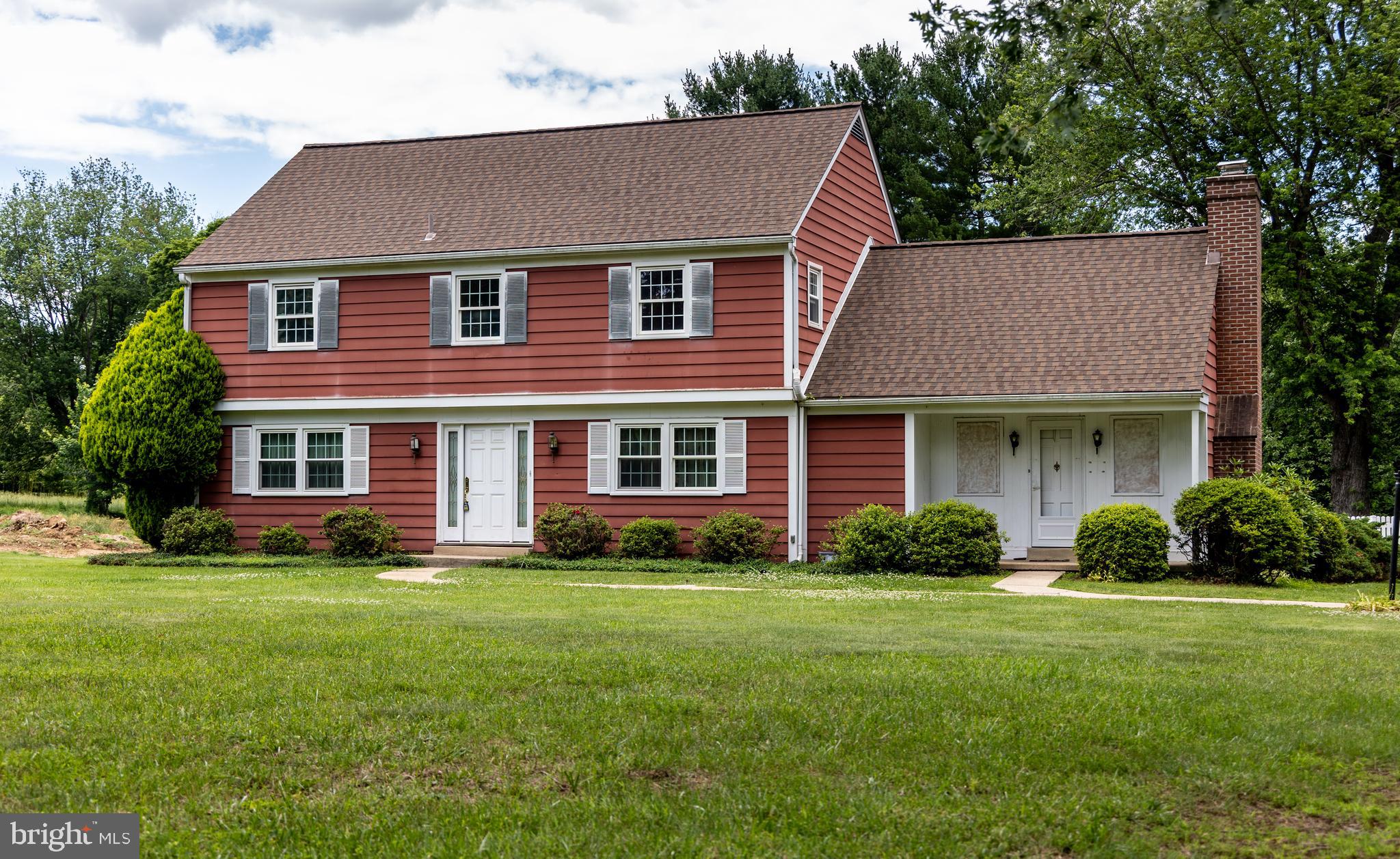 a front view of a house with a yard and trees