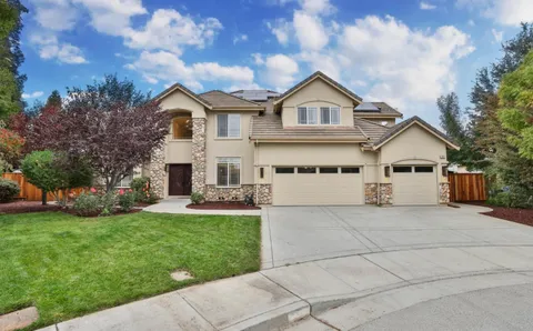 a view of house with a big yard and large trees