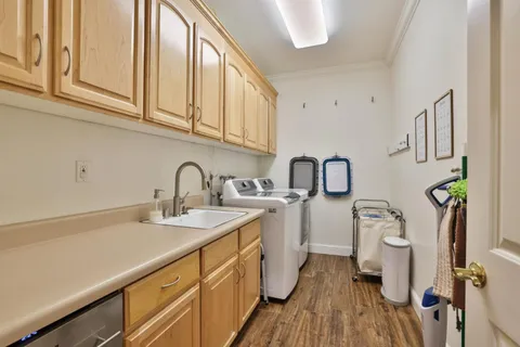 a view of a sink and dishwasher with wooden floor
