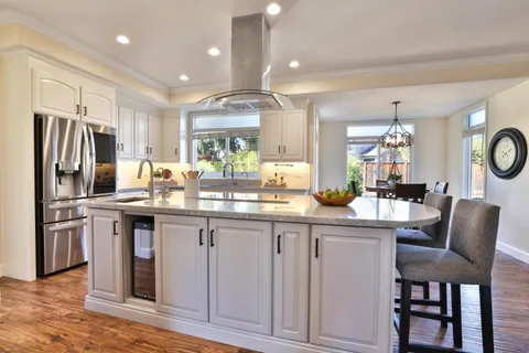 a kitchen with stainless steel appliances granite countertop a sink a stove a refrigerator and island