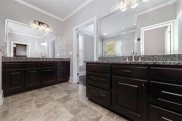 a bathroom with a granite countertop sink a toilet a mirror and shower