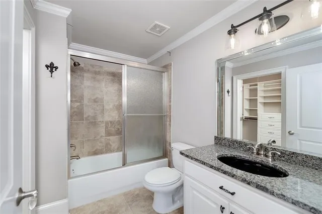 a view of an empty room with wooden floor and a ceiling fan