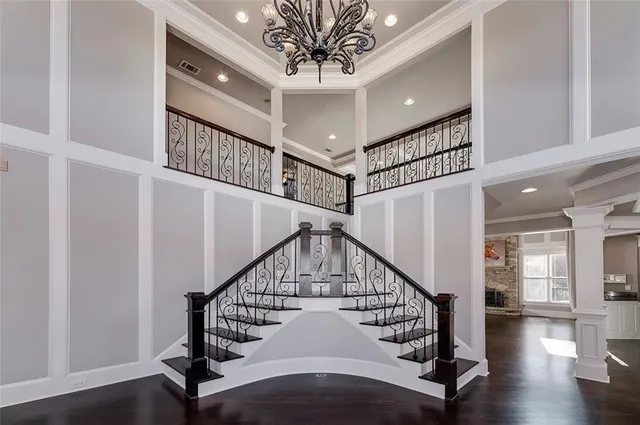 an empty room with wooden floor fireplace and windows