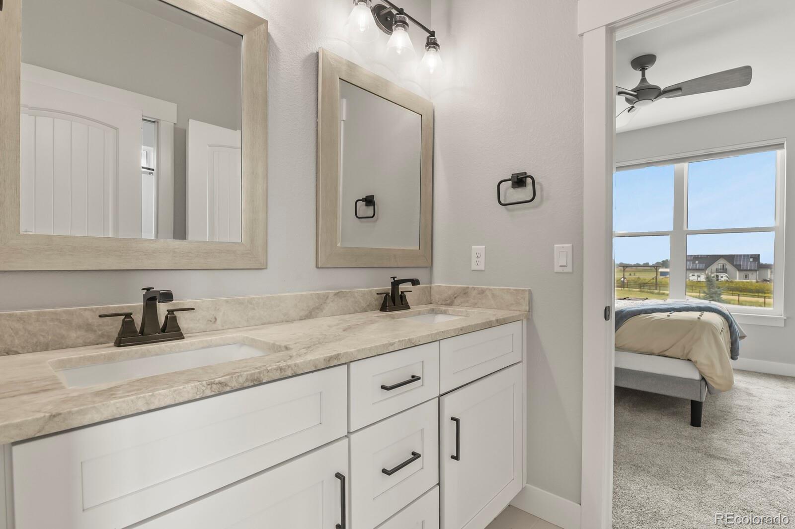 11617 Harpenden Court Fort Lupton, CO 80621 - Photo 27 of 50 a en suite bathroom with a granite countertop sink and a mirror