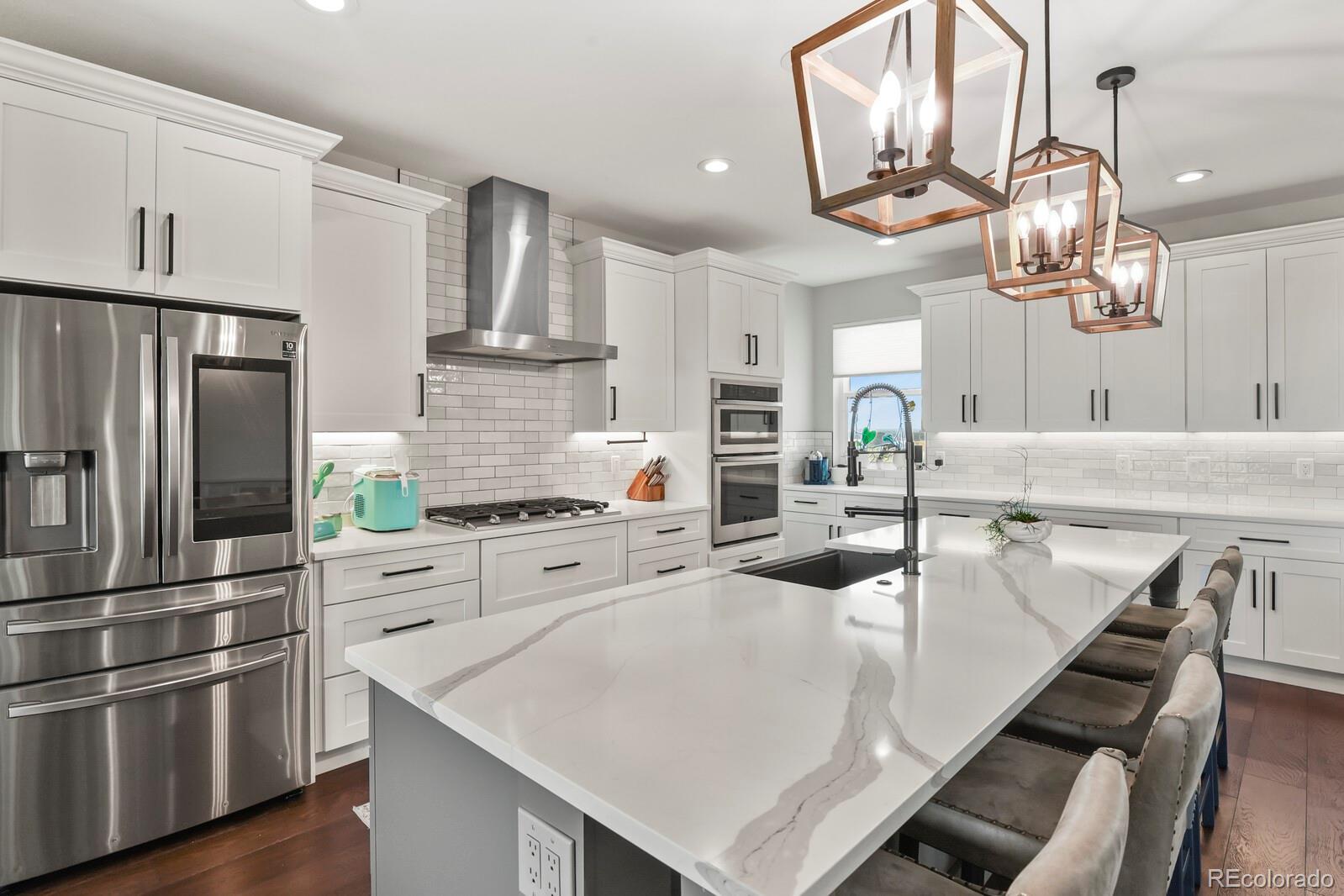 11617 Harpenden Court Fort Lupton, CO 80621 - Photo 4 of 50 a kitchen with stainless steel appliances granite countertop a sink a stove and a refrigerator