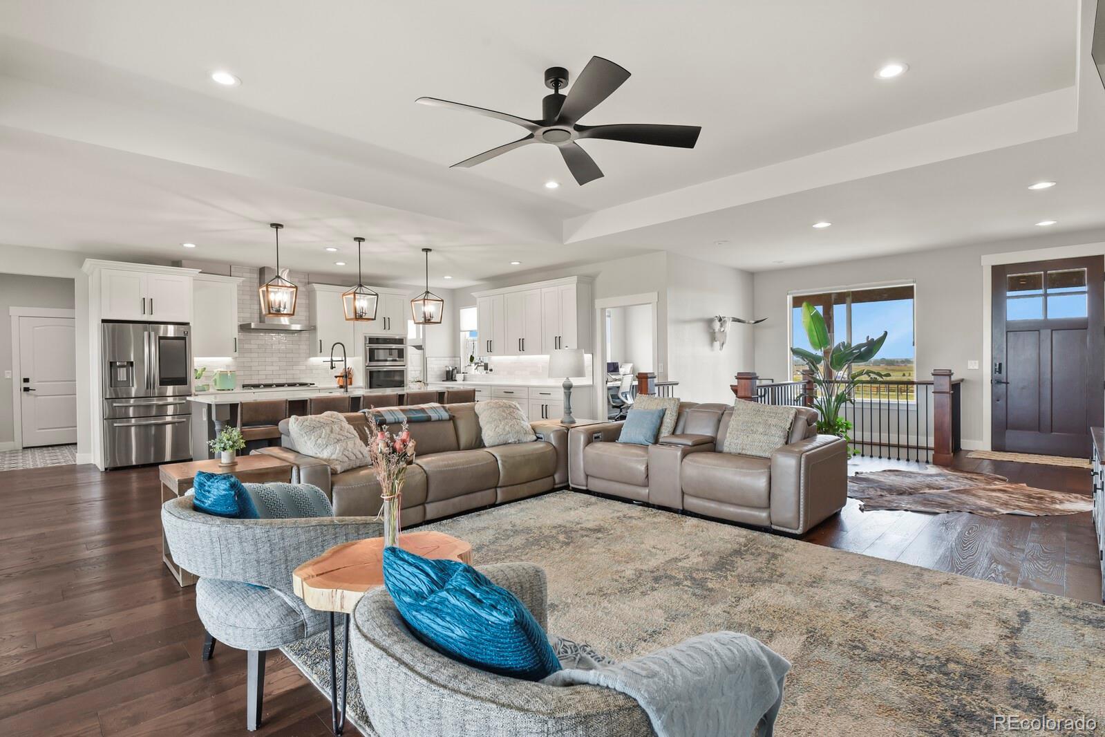 11617 Harpenden Court Fort Lupton, CO 80621 - Photo 9 of 50 a living room with furniture kitchen view and a wooden floor