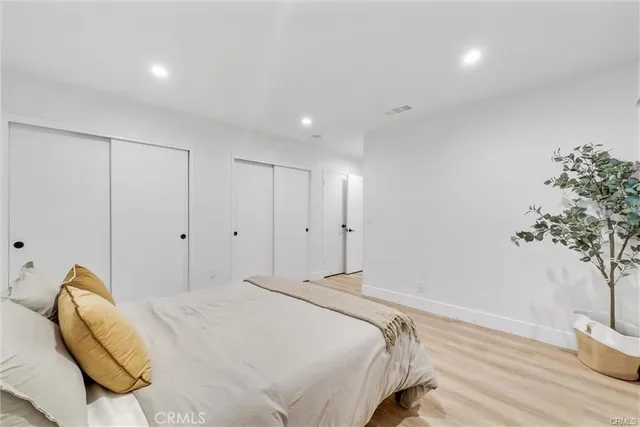 a bedroom with a bed and a potted plant