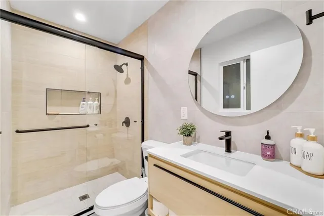 a bathroom with a sink a toilet a mirror and shower