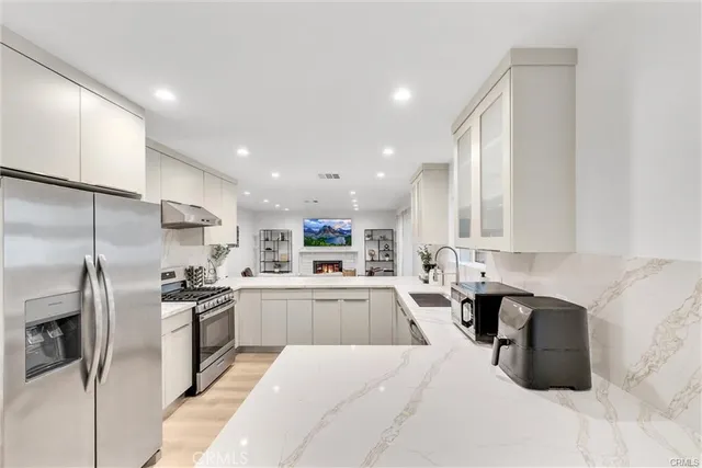 a kitchen with granite countertop a sink stainless steel appliances and cabinets