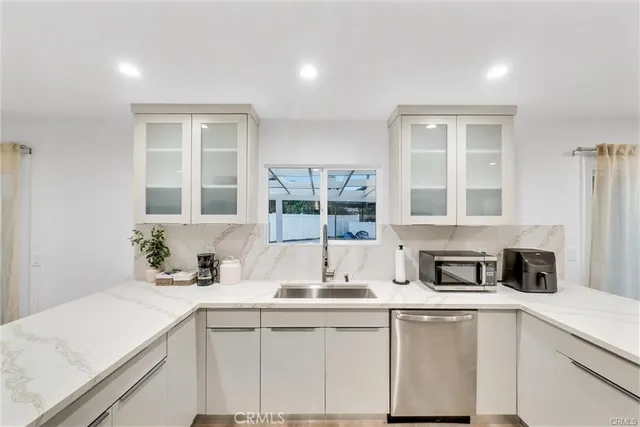 a kitchen with stainless steel appliances granite countertop a sink a stove and cabinets