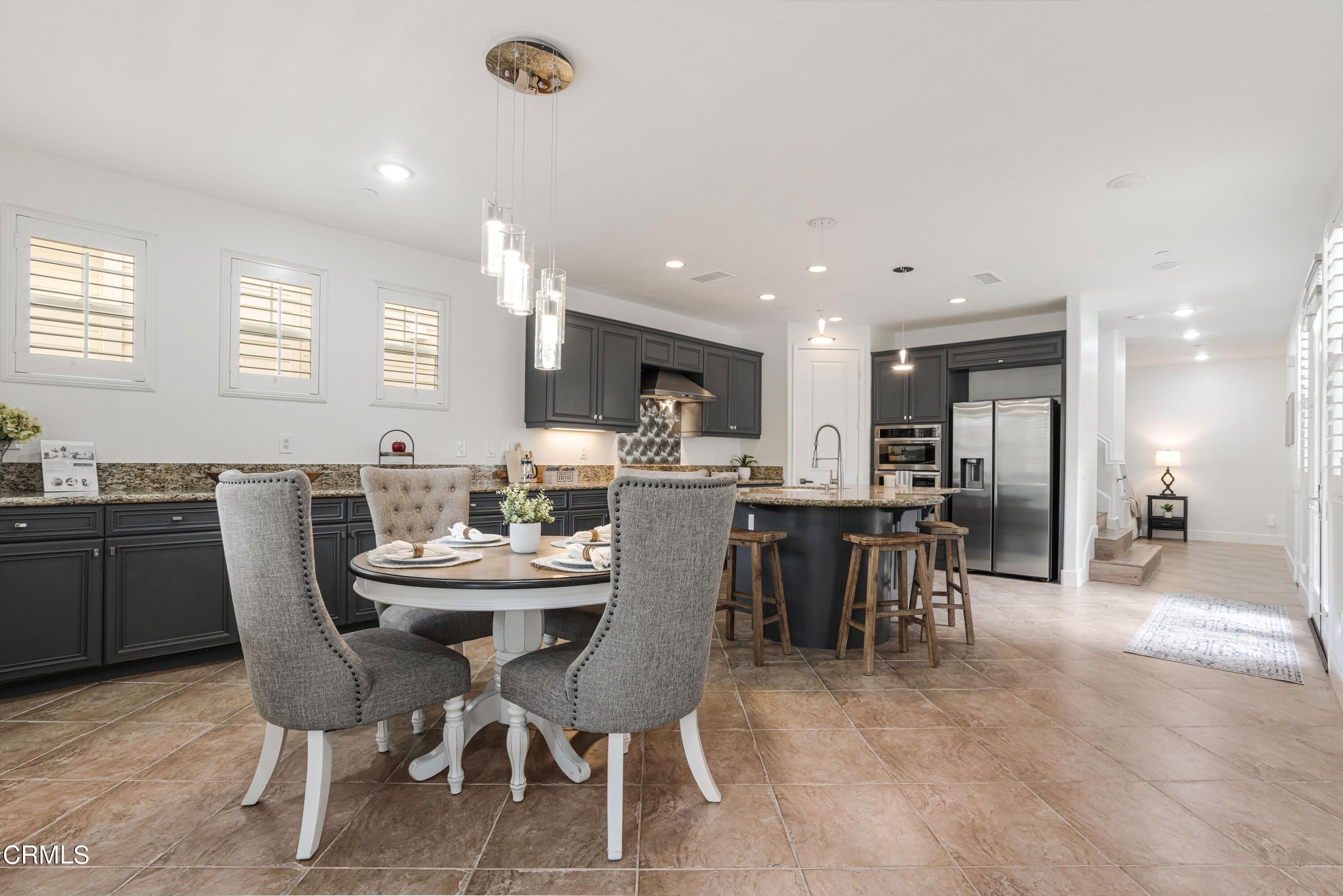 1404 Donegal Way Oxnard, CA 93035 - Photo 8 of 51 a dining area with a table chairs and a kitchen view