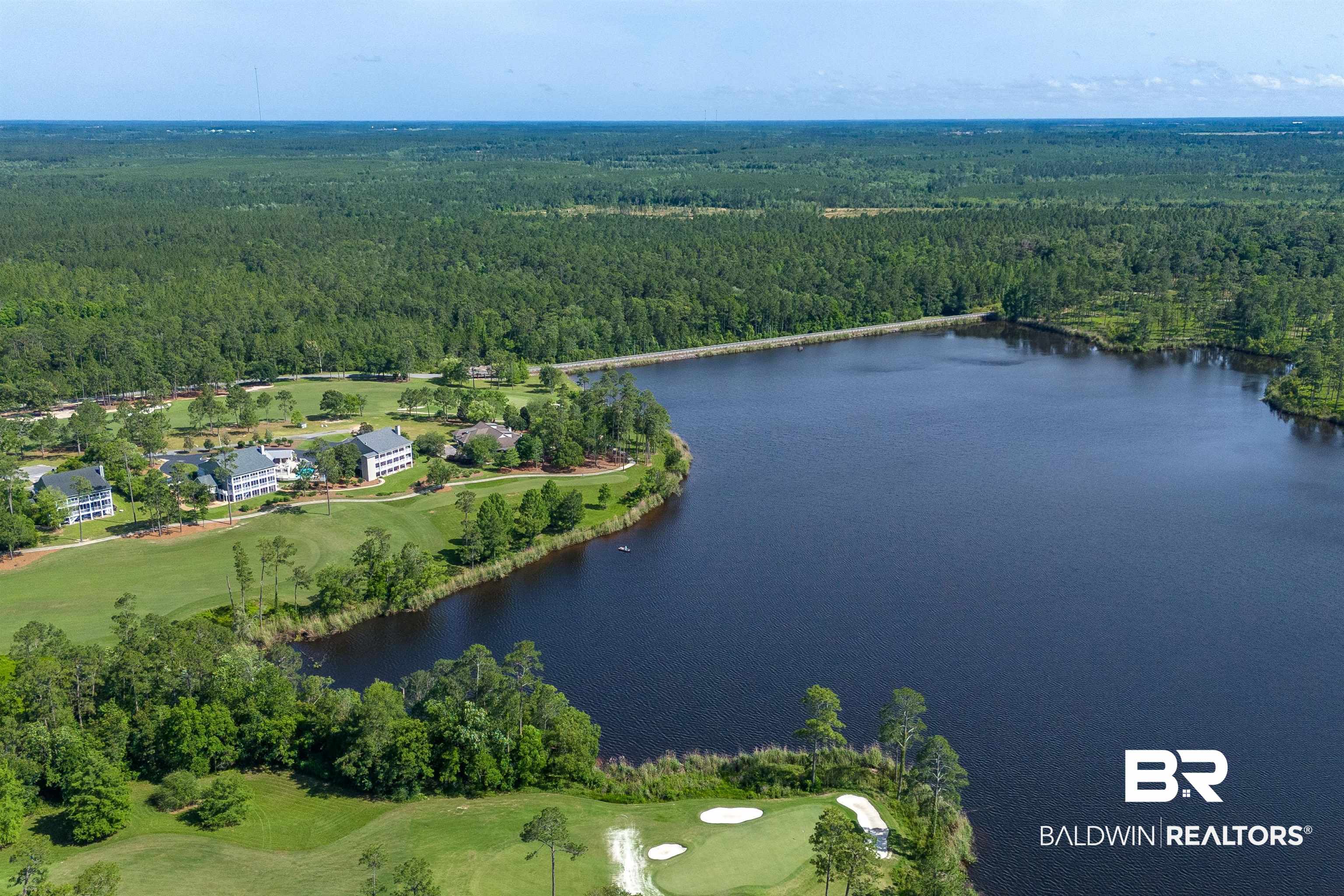 32760 Steelwood Ridge Road, Unit 7 Loxley, AL 36551 - Photo 60 of 64 Aerial view of property and surrounding area with a heavily wooded area, a large body of water, and a golf course
