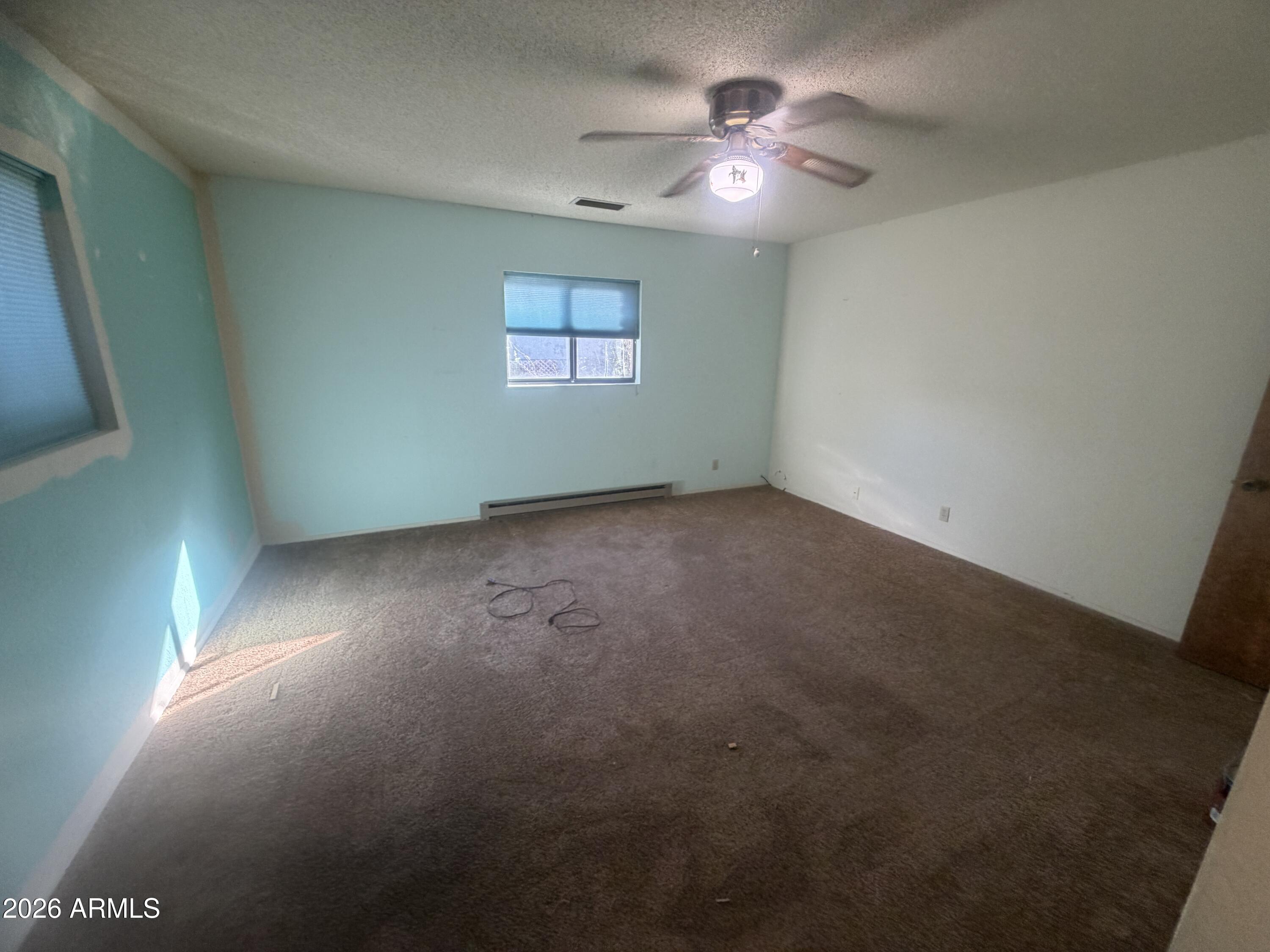 3255 East Rimrock Drive Rimrock, AZ 86335 - Photo 11 of 18 en empty room with windows and chandelier fan