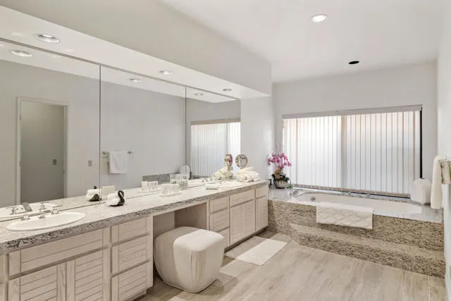 a bathroom with double vanity sinks and a shower