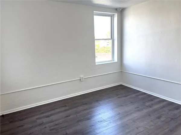 a view of an empty room with wooden floor
