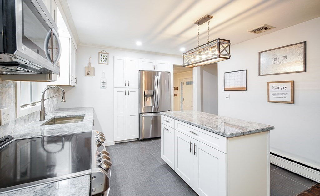 148 Glenoak Drive Springfield, MA 01129 - Photo 6 of 28 a kitchen with stainless steel appliances granite countertop a refrigerator a stove and a sink with wooden floor