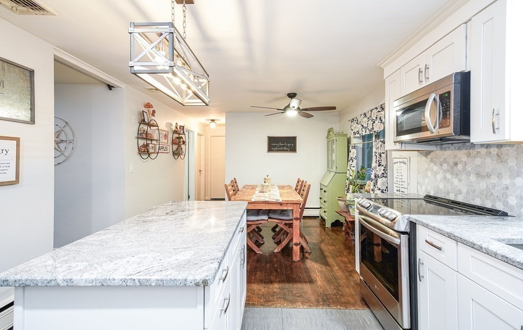 148 Glenoak Drive Springfield, MA 01129 - Photo 7 of 28 a open kitchen with stainless steel appliances granite countertop a stove oven and a white cabinets