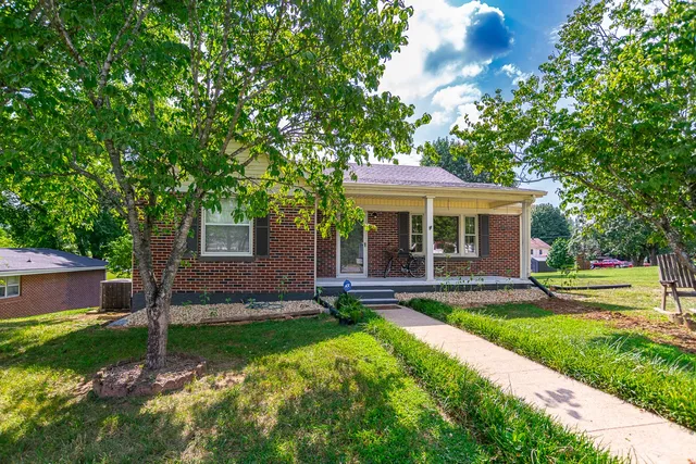 a view of a house with a yard and tree s