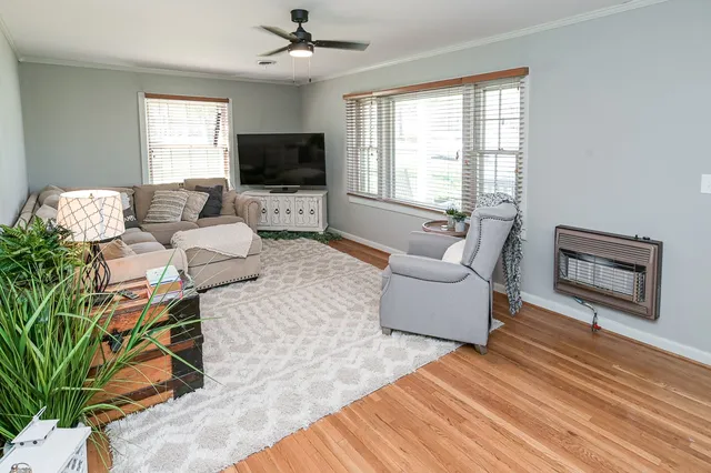 a living room with furniture a flat screen tv and a window