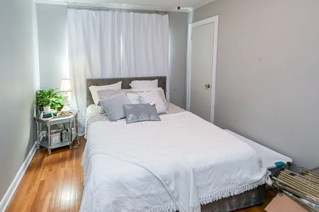 a bedroom with a bed and a potted plant