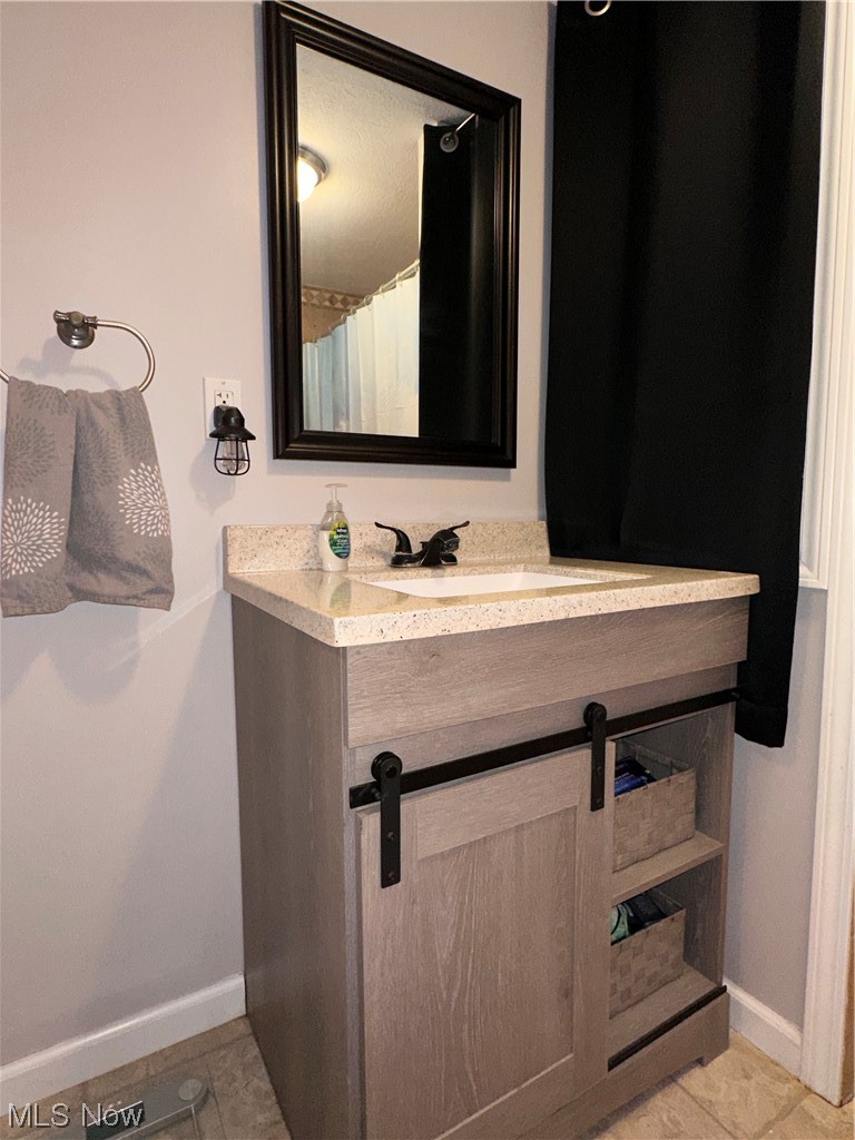 5770 Jaycox Road North Ridgeville, OH 44039 - Photo 18 of 31 Bathroom featuring vanity, light tile floors, and mirror