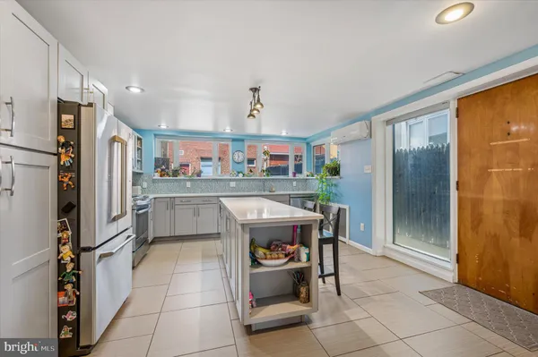 a kitchen with stainless steel appliances kitchen island granite countertop a refrigerator and cabinets