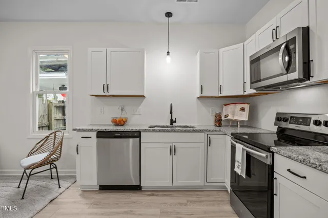 a kitchen with stainless steel appliances granite countertop a stove top oven a sink dishwasher and a microwave oven on the blue kitchen countertops