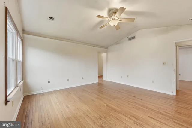 wooden floor in an empty room with a window