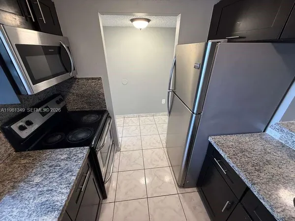 a kitchen with granite countertop a refrigerator and a stove