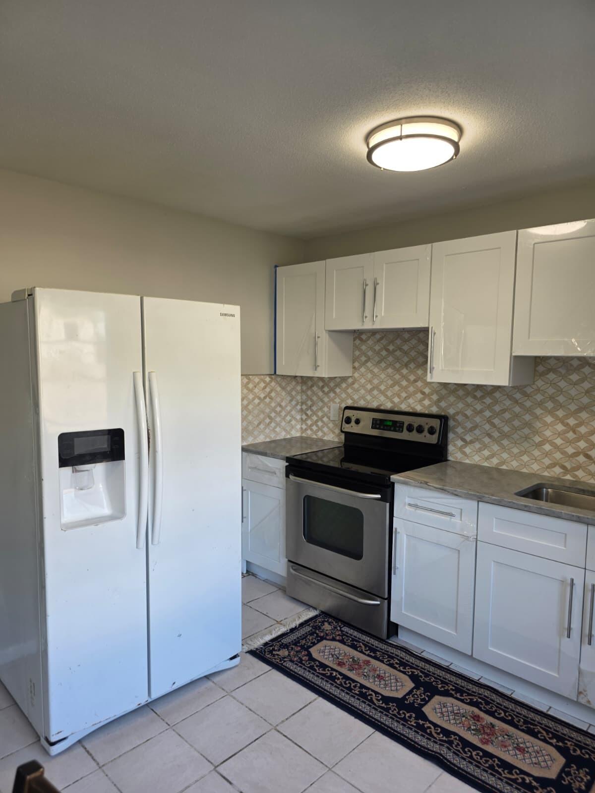 3386 Rudolph Road Lake Worth Beach, FL 33461 - Photo 14 of 25 a kitchen with stainless steel appliances granite countertop a stove a refrigerator and a granite counter tops