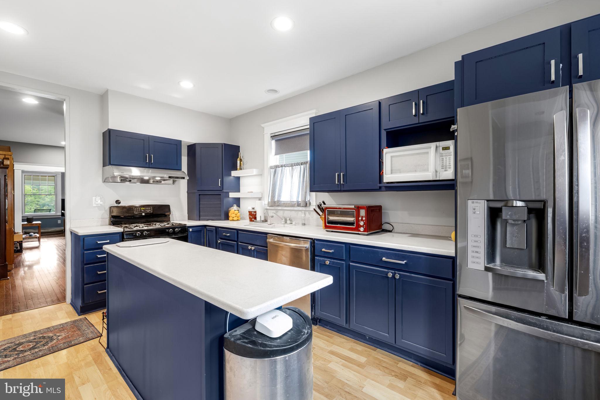 765 Dividing Road Severna Park, MD 21146 - Photo 8 of 17 a kitchen with stainless steel appliances granite countertop a refrigerator a stove a sink a stove and a refrigerator with wooden floor