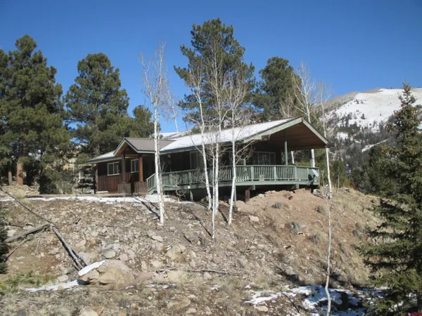a view of a house with a small yard and wooden fence