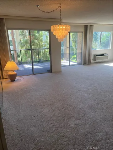 a view of a livingroom with furniture and floor to ceiling window