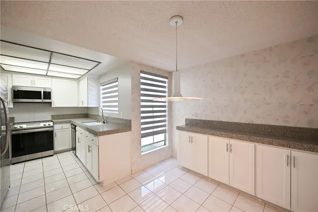 a kitchen with granite countertop white cabinets and white appliances