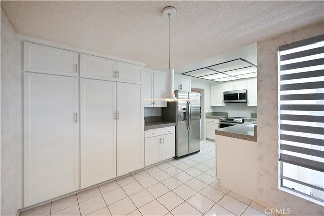 a kitchen with white cabinets and white appliances