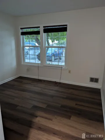 a room with wooden floor and windows