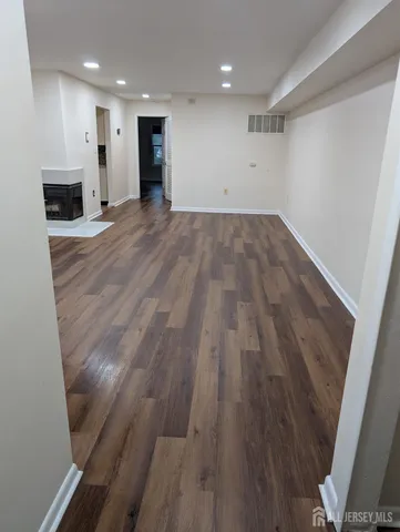 a view of empty room with wooden floor and fireplace