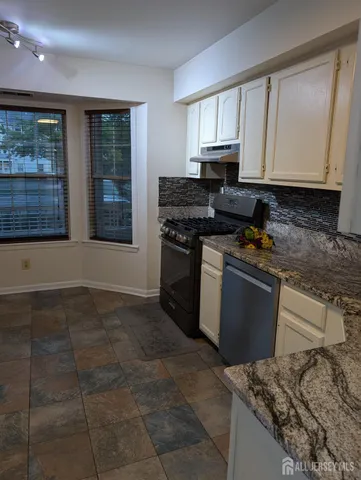 a kitchen with a stove a sink and a microwave