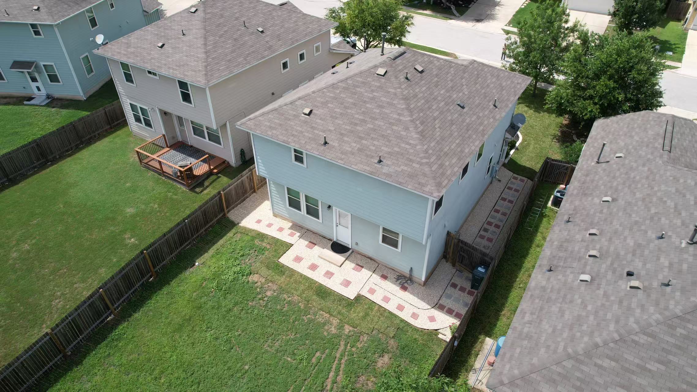 251 Triumph Road Buda, TX 78610 - Photo 23 of 26 An aerial perspective reveals a private yard, showcasing a charming deck and stone paver patio, perfect for outdoor enjoyment.