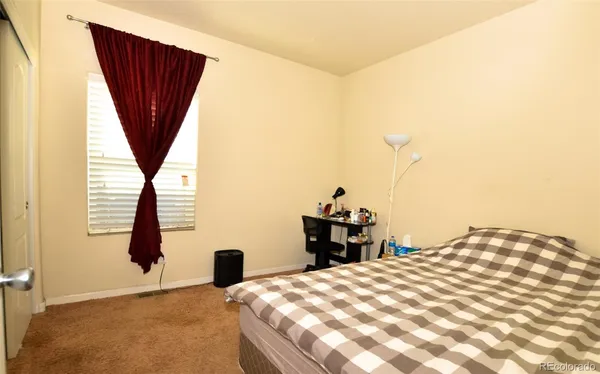 a bedroom with a bed and a large window