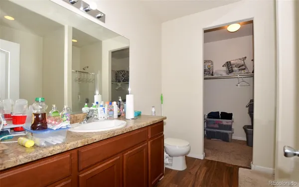 a bathroom with a granite countertop sink mirror vanity and toilet