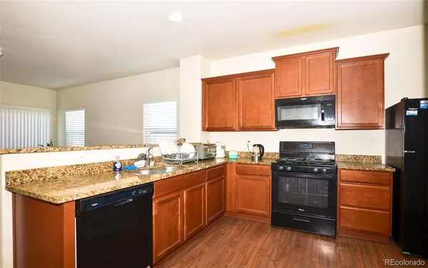 a kitchen with a sink stove top oven and refrigerator