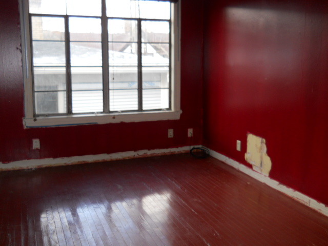 802 West 3rd Street Sterling, IL 61081 - Photo 11 of 21 an empty room with wooden floor and windows
