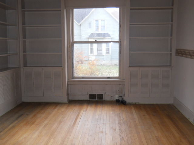 802 West 3rd Street Sterling, IL 61081 - Photo 17 of 21 an empty room with wooden floor and windows